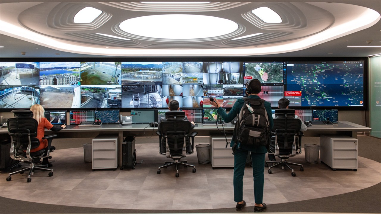 People in front of many surveillance monitors